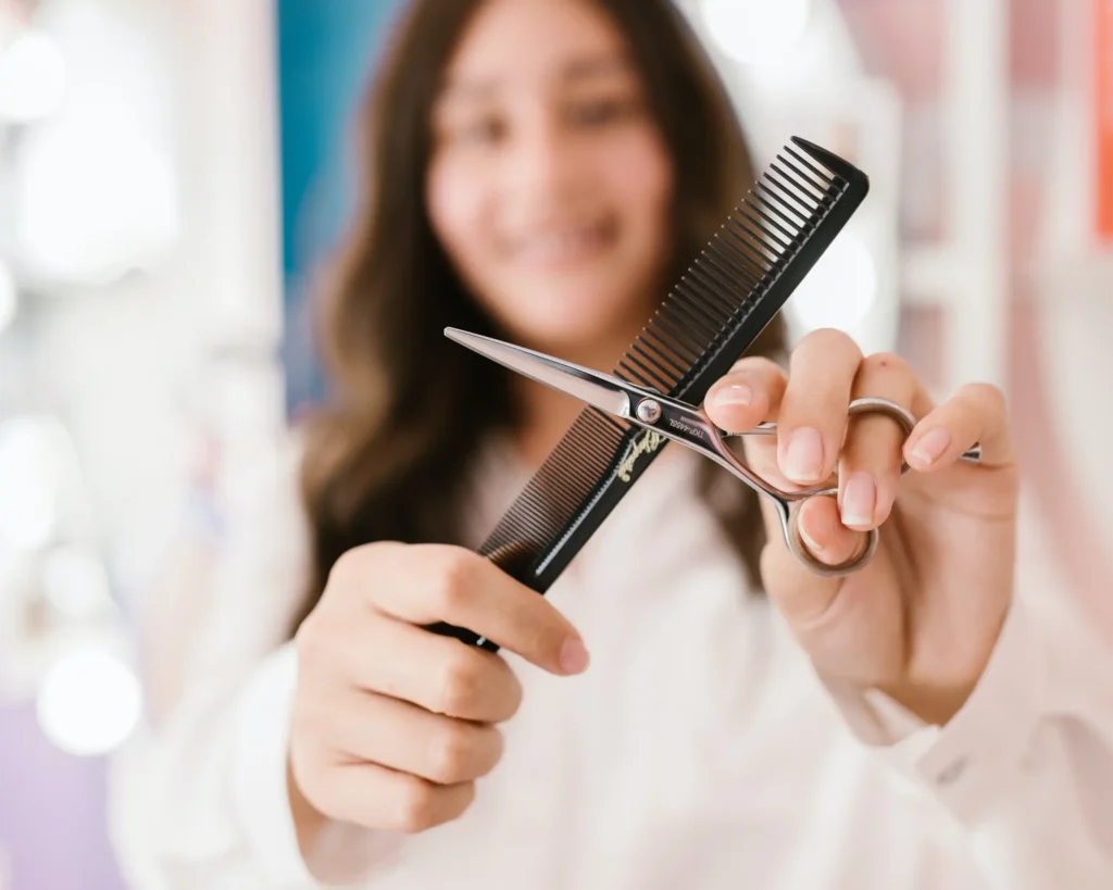A woman holding scissors and comb.