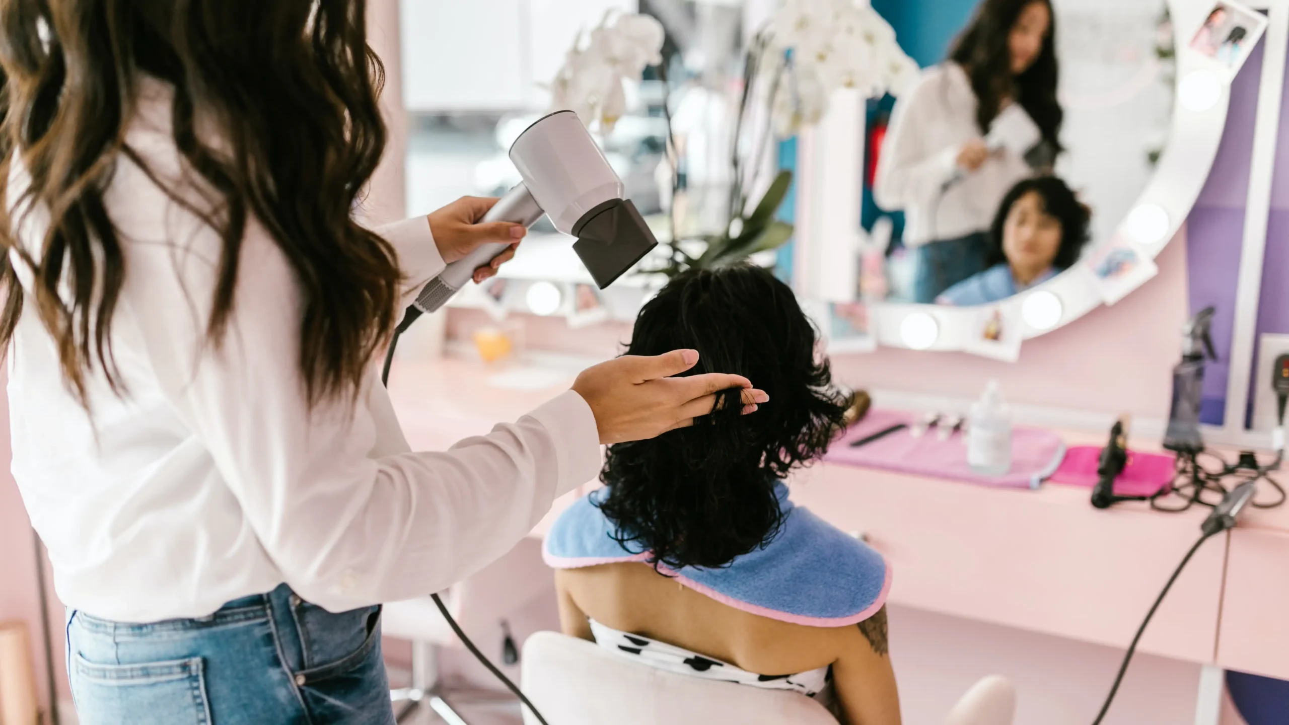 An over the shoulder photograph of a woman getting her hair cut. 